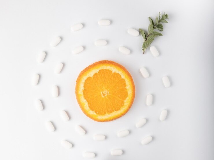 orange and sage surrounded by white tablets representing vitamin c content