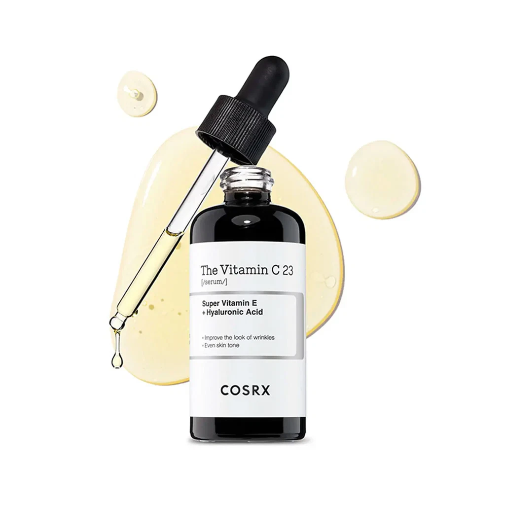 Cosrx The Vitamin C 23 Serum with Open Applicator Dripping Golden Serum onto White Background