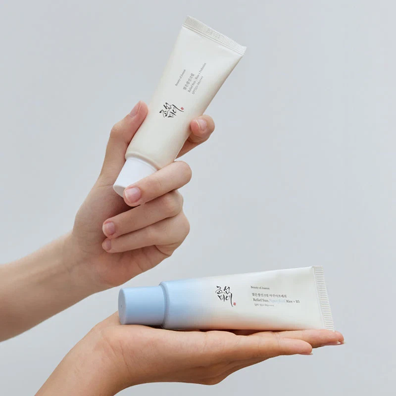 Beauty of Joseon Dual Sun Serums (Relief Sun and Aqua Fresh) being held by model