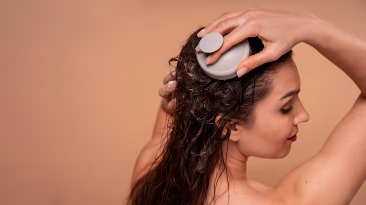 Woman washing her hair, using a scalp brush